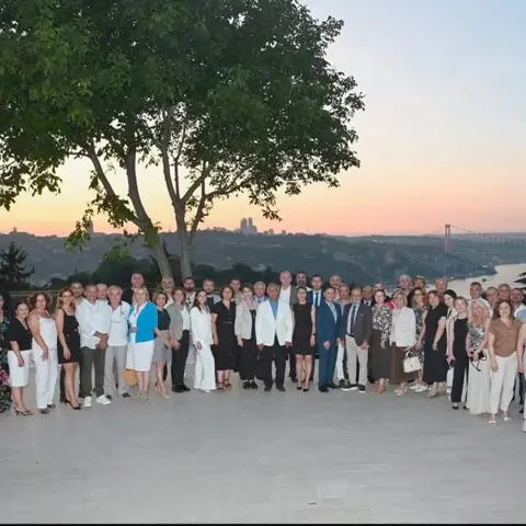 İSAD üyeleri Boğaz manzaralı terasta gün batımında toplu fotoğraf çektiriyor