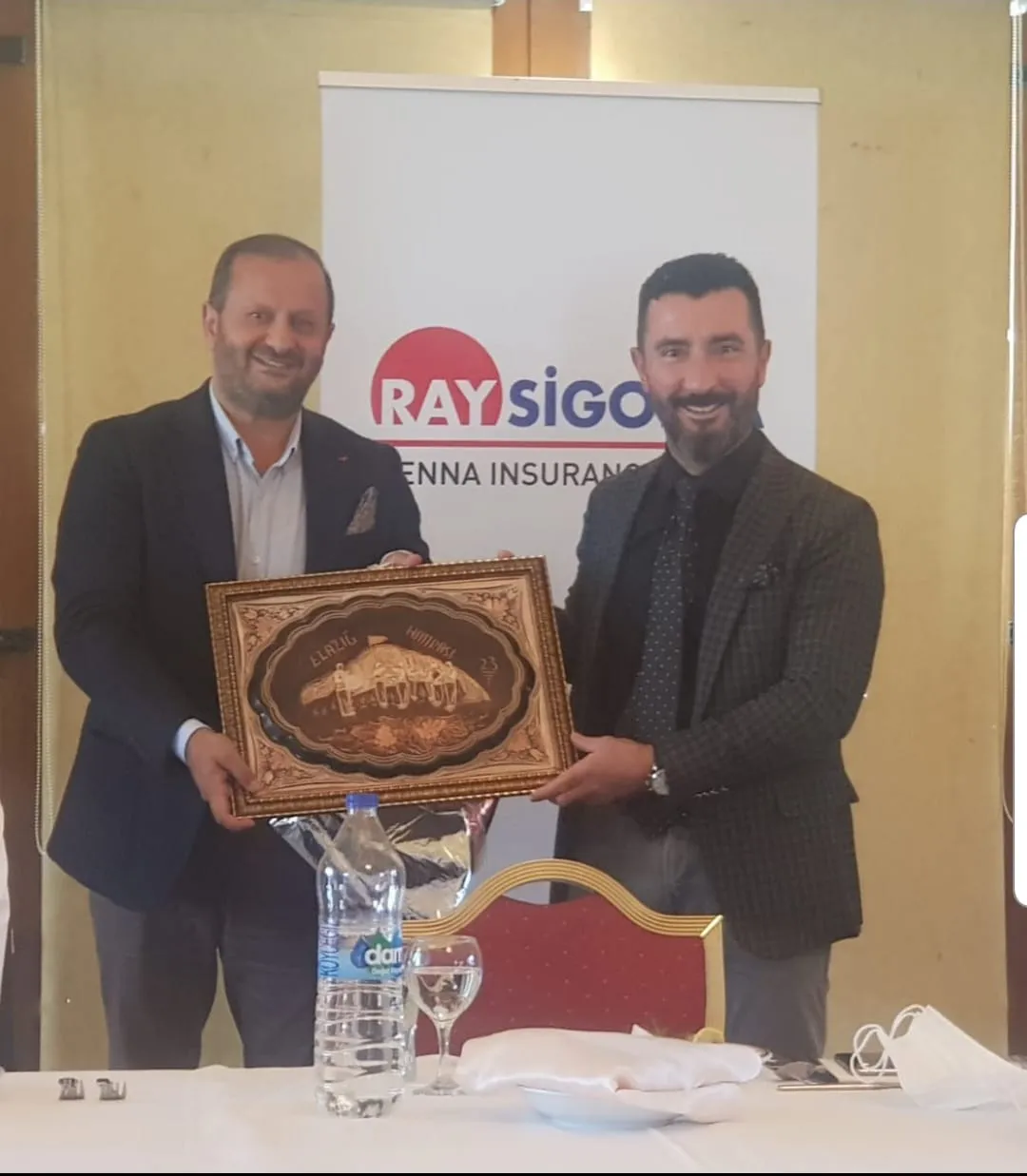 Ray Sigorta standında iki kişinin Elazığ temalı hatıra plaketi takdimi