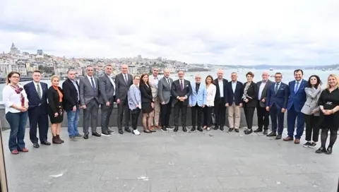 İstanbul Haliç manzarası önünde geniş katılımcı grubunun toplu fotoğrafı