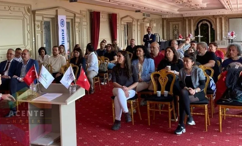 TEKSADER genel kurulu: salon dolusu katılımcı, kürsüde Allianz afişi ve Türk bayrakları