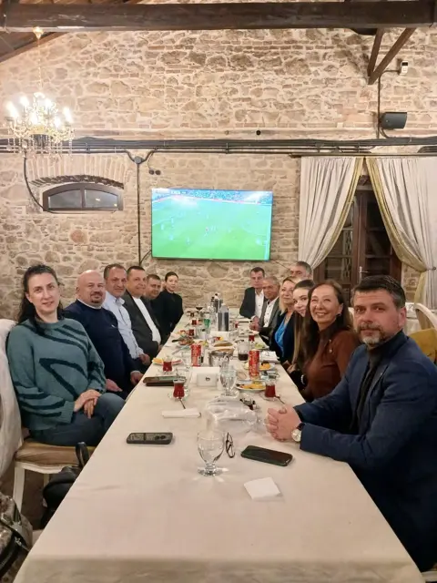 ESAD üyeleri taş duvarlı restoranda uzun masada yemek sohbetinde
