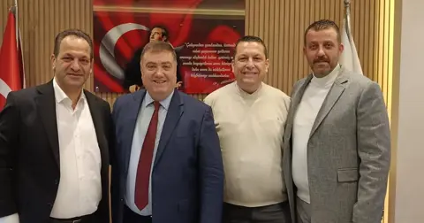 Dört kişi, Atatürk portreli pano önünde ayakta grup fotoğrafında