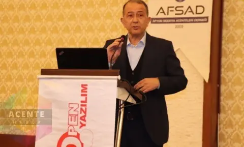 AFSAD etkinliğinde kürsüde konuşan kişi, arkada Open Yazılım afişi